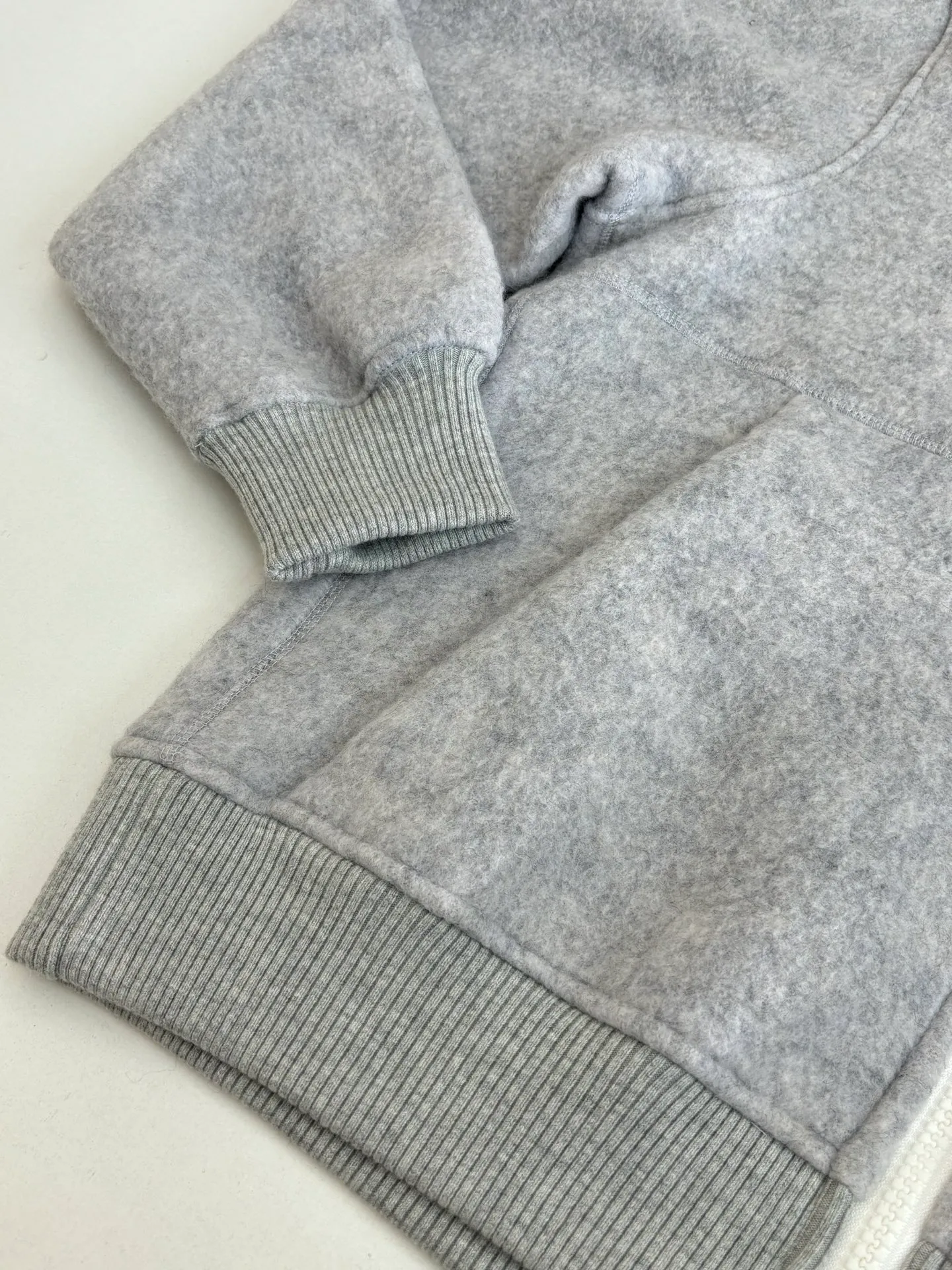 P810 Canada Goos*/Big Goose Fleece Badge Hooded Jacket The fabric is made of wool as the main body, with a very small amount of spandex and polyester fiber blended into the wool fleece fabric. The sleeves and hem are closed with 2×2 ribbing. Its strong elasticity can closely fit wrists and waists of different thicknesses, forming an effective 'seal' to prevent cold wind from blowing back. It can still maintain its original shape after repeated stretching and use, and is not easy to loose and deform. And the ribbed cuffs can convey a sense of design and enhance the visual beauty.  Size：S/M/L/XL